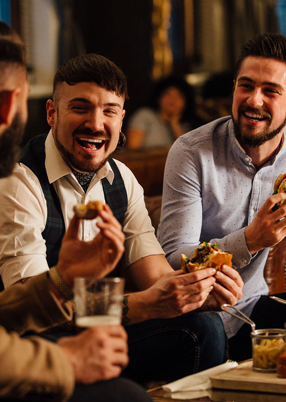 man smiling and laughing with burgers in your hands
