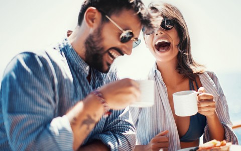 man and woman laughing and enjoying breakfast