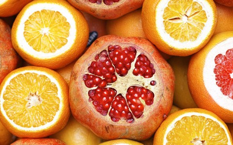 orange and pomegranates cut open on top 