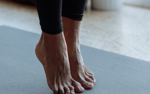 close up of woman stretching standing on her bent toes