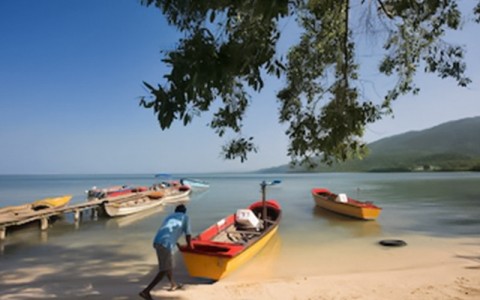 local village image of a man pushing his canoe away from the sand