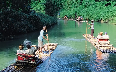 martha brae image of people sitting on bamboo boats going down a river