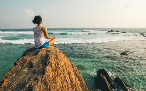 nature of sound image of a woman sitting on a rock meditating