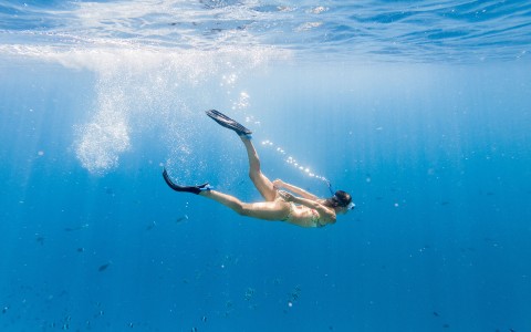 woman swimming in water in snorkeling gear