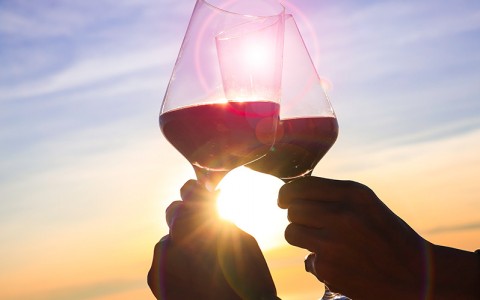 two glasses of wine with the sun in the background