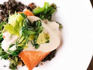 Salmon with beluga lentils, soubise, lemon, fresh herbs, and grilled broccolini