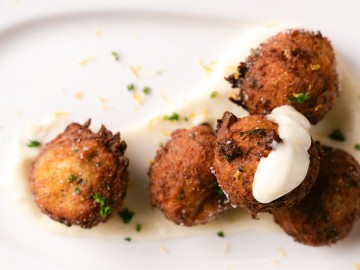 Close up of crab croquettes with aioli and seasoning