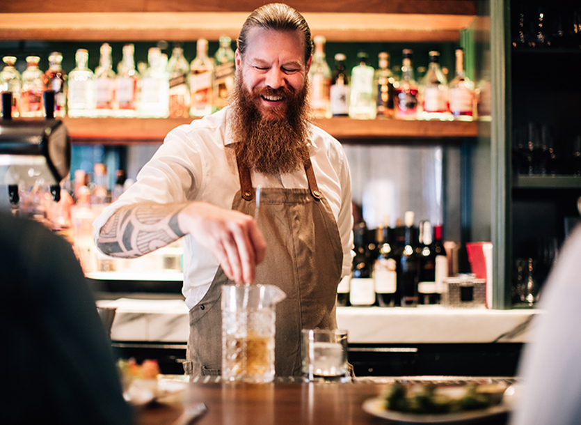 bar tender making a drink and smiling