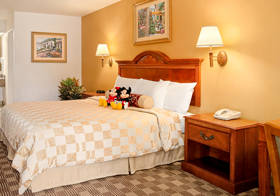 queen bed with mickey and minnie toys on top