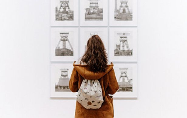 woman looking at art on a white wall