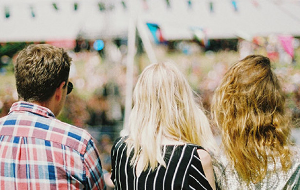 a man and 2 women looking at a white festival tent