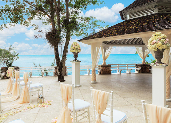 wedding ceremony set up on a terrace with a gazebo overlooking the ocean