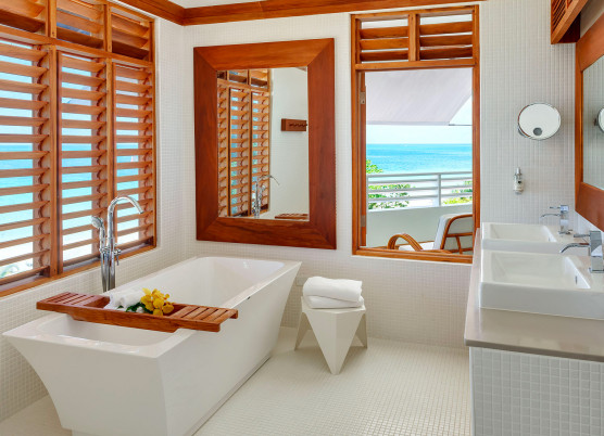 a bathroom with large white soaking tub and beach views