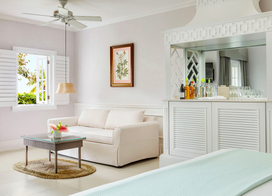 one bedroom beachfront suite living room with light colored beach inspired furniture