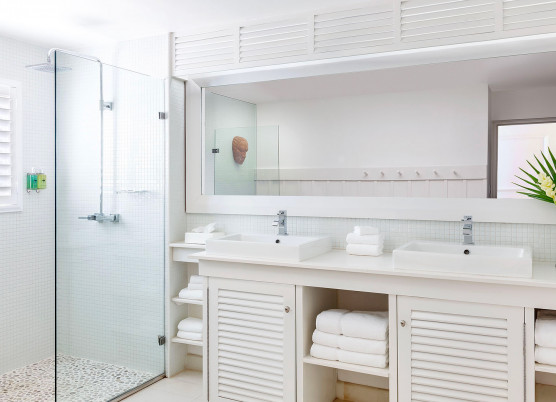 one bedroom beachfront suite bathroom with cabinets and furnishing and a glass walk in shower
