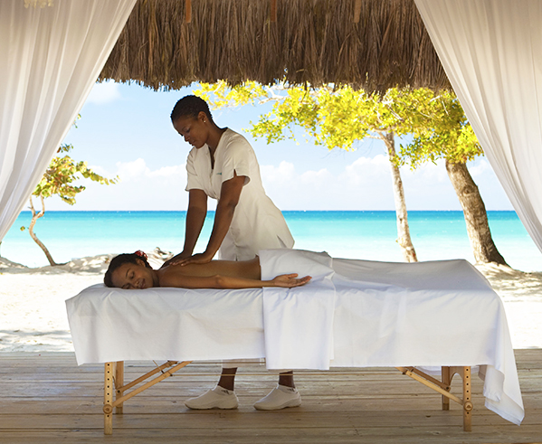 woman getting a massage outside in front of the ocean