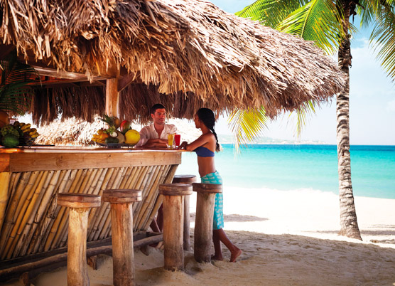 couple having drinks at the bamboo bar on the beach