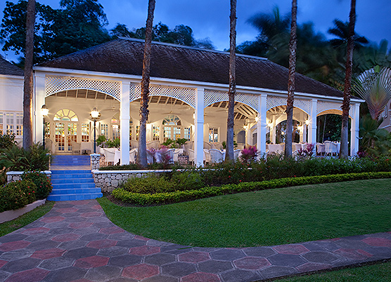 long white gazebo with dining tables set up underneath at night