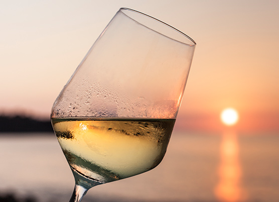 white wine in a glass overlooking sunset