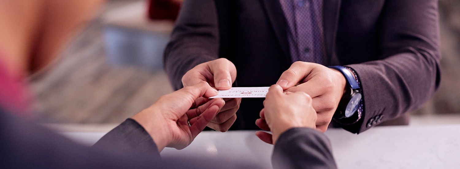 a hotel employee handing a room card to a guest