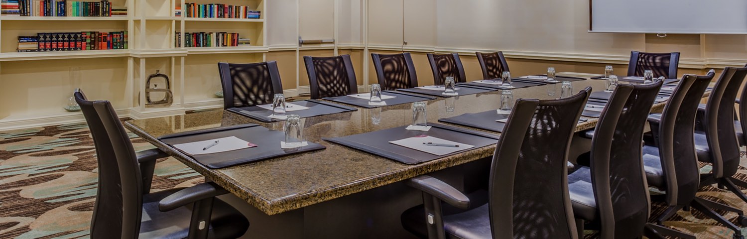 black chairs sitting at a granite meeting room table