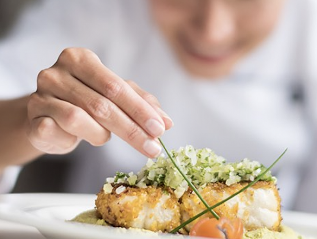 Close up of a chef plating food