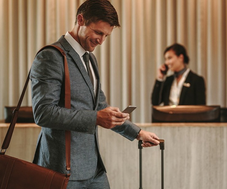 Business man in suit with rolling suitcase