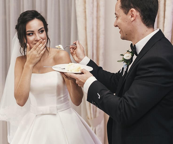 Wedding couple sharing cake during reception 