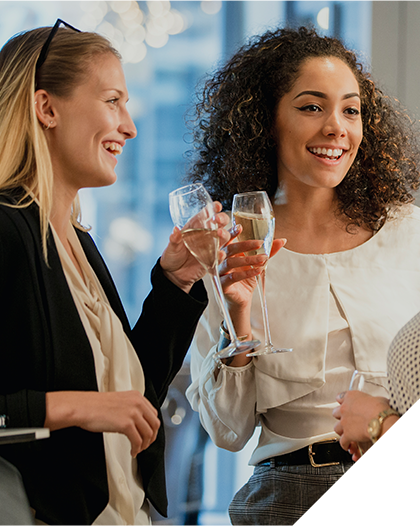 Two women talking with champagne glasses in hand