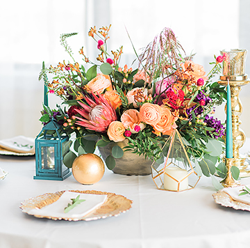 a wedding place setting with colorful flowers