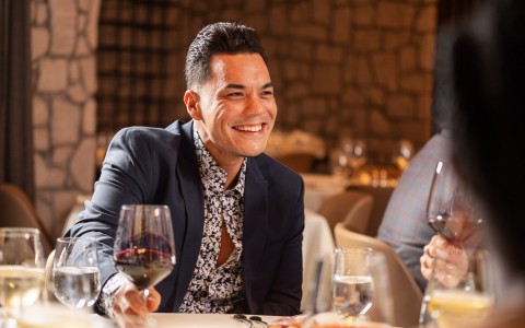 man with wine smiling at dinner