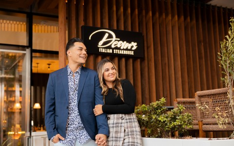man and woman walking out of dean's steakhouse and smiling 