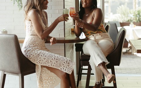 two women cheerings their drink