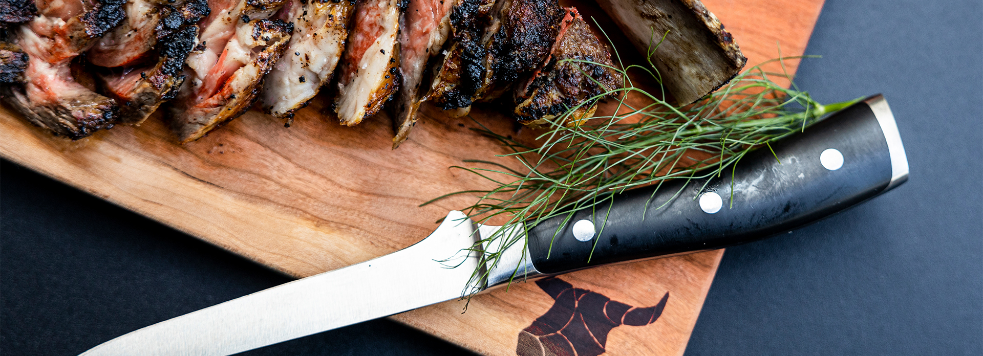 cropped image of meat on a cutting board with a steak knife 