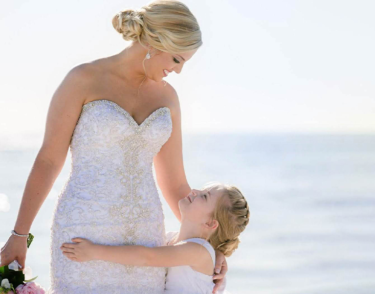 bride looking at her daughter while they smile at each other 