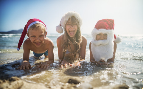 kids at the beach dressed as santa