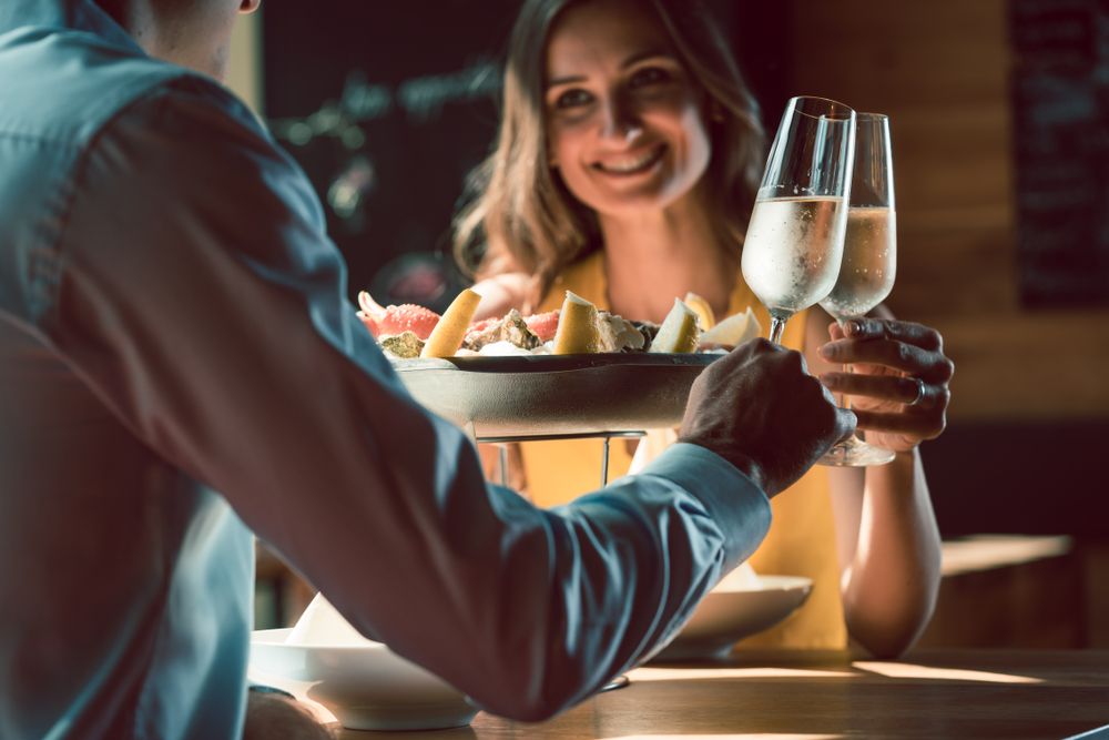 young couple toasting with champagne over dinner