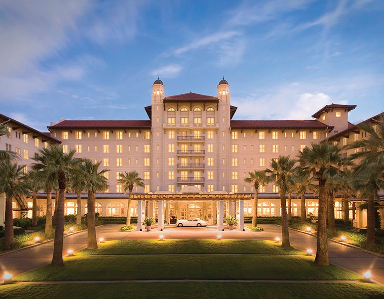 A large lawn area in front of hotel Galvez lit up at night