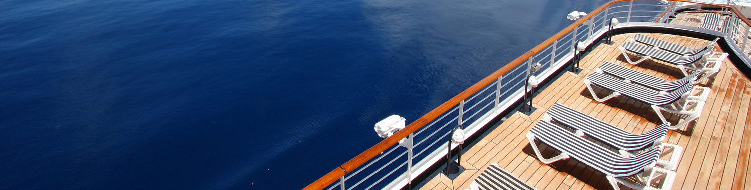 cruise ship deck with lounge chairs looking over the ocean