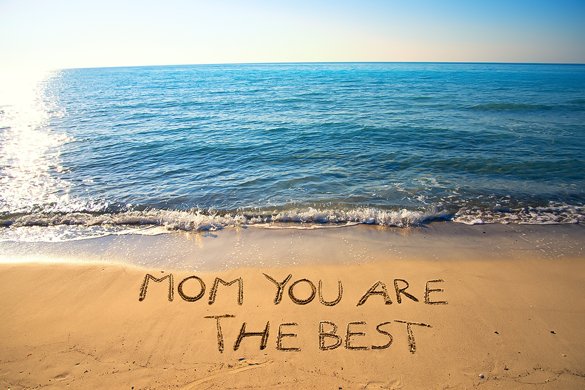 beach photo with a letters made by sand that says mom you are the best