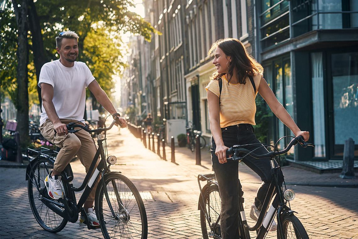 a man and a woman riding a city bike