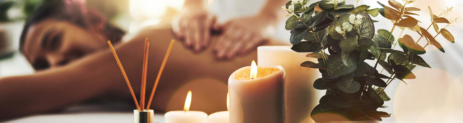 candles at a spa as a woman gets a massage