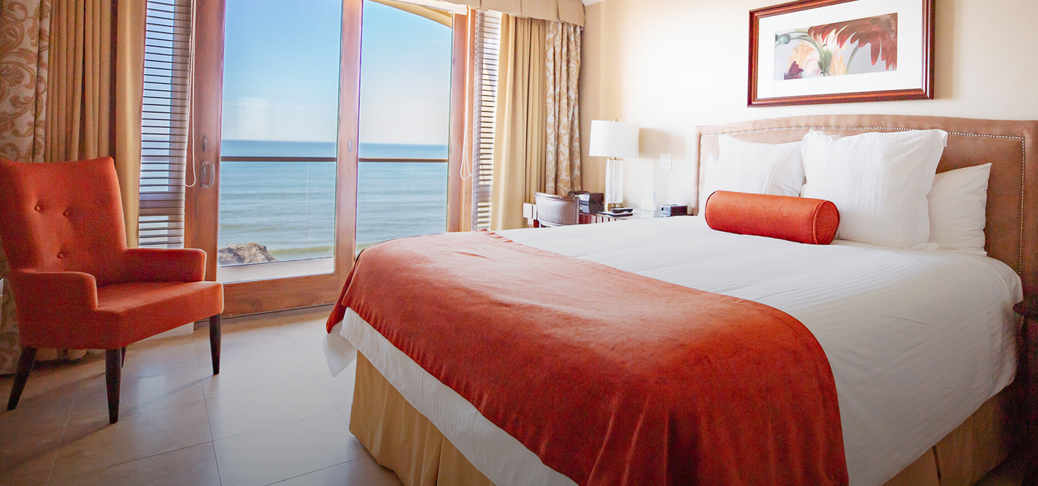 hotel bed with large window with ocean view
