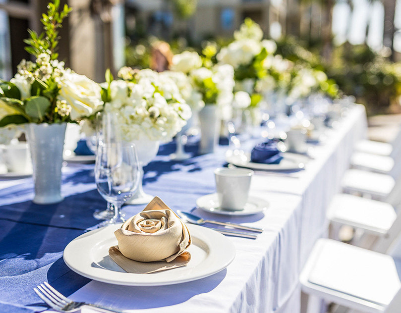 long wedding table with blue table runner and white flower centerpieces
