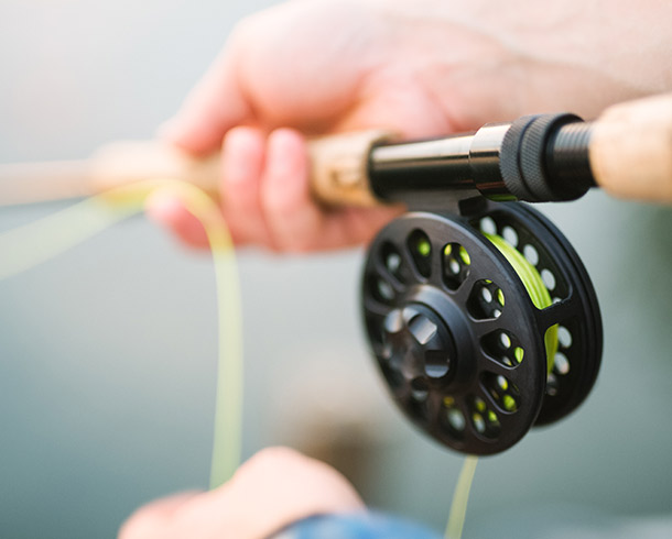 hands holding onto a fishing rod