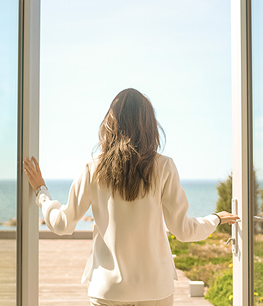 woman with long hair standing on her balcony
