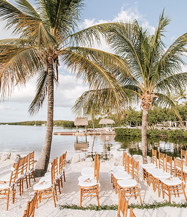 rows of chairs lined up for a wedding at the edge of the marina