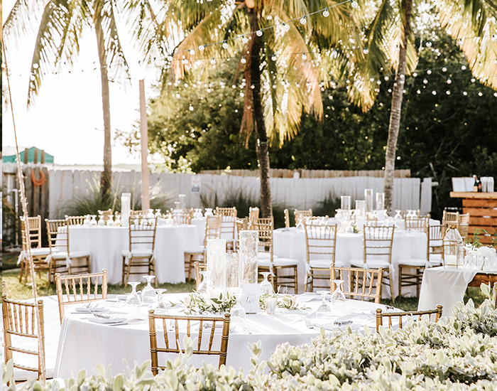 wedding venue with white chairs and round tables outside