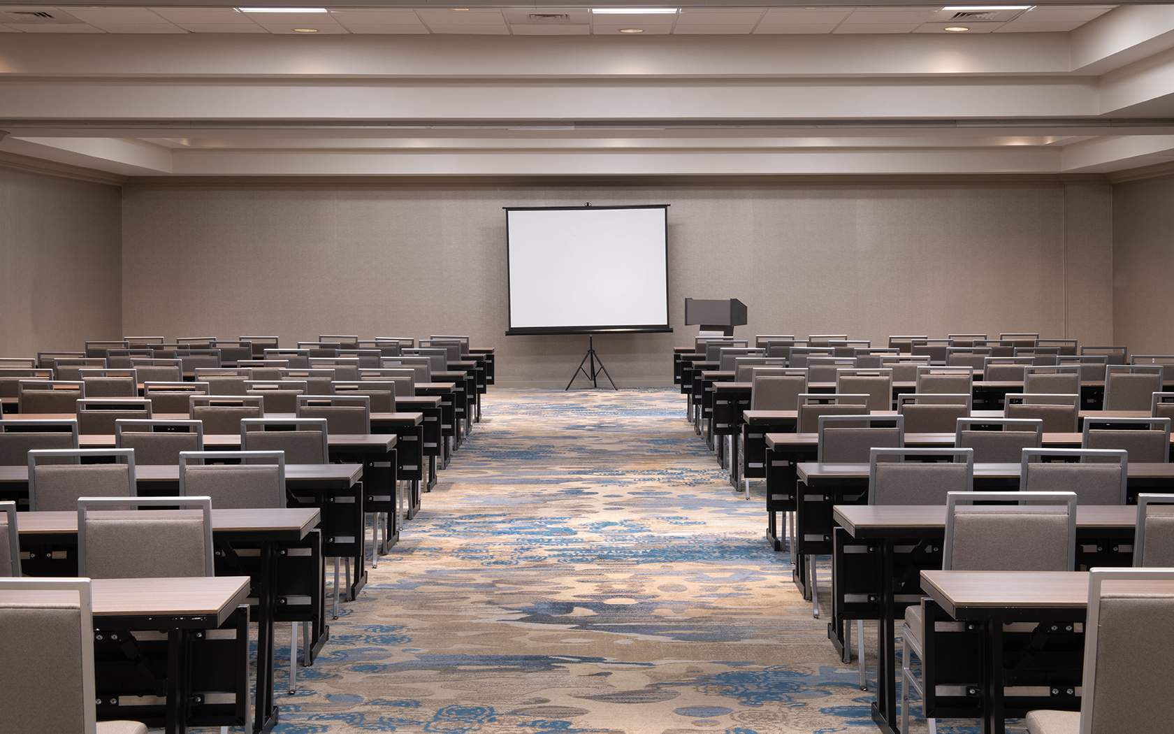 large sized event space with many rows of seats with tables 