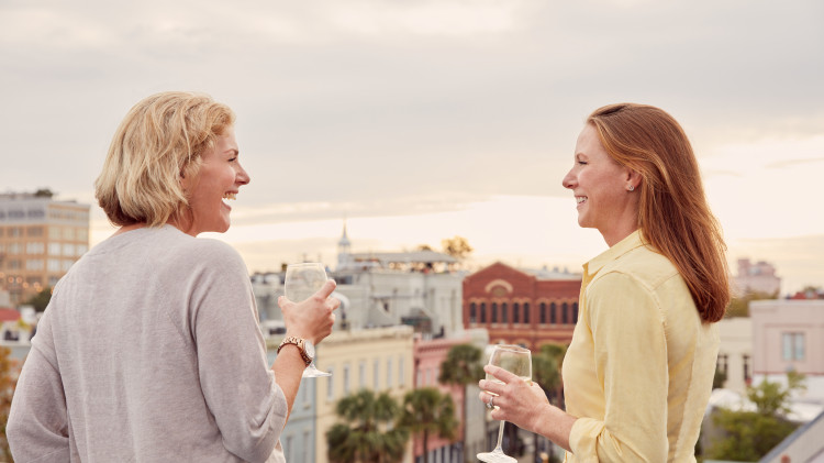 two women on a rooftop having wine